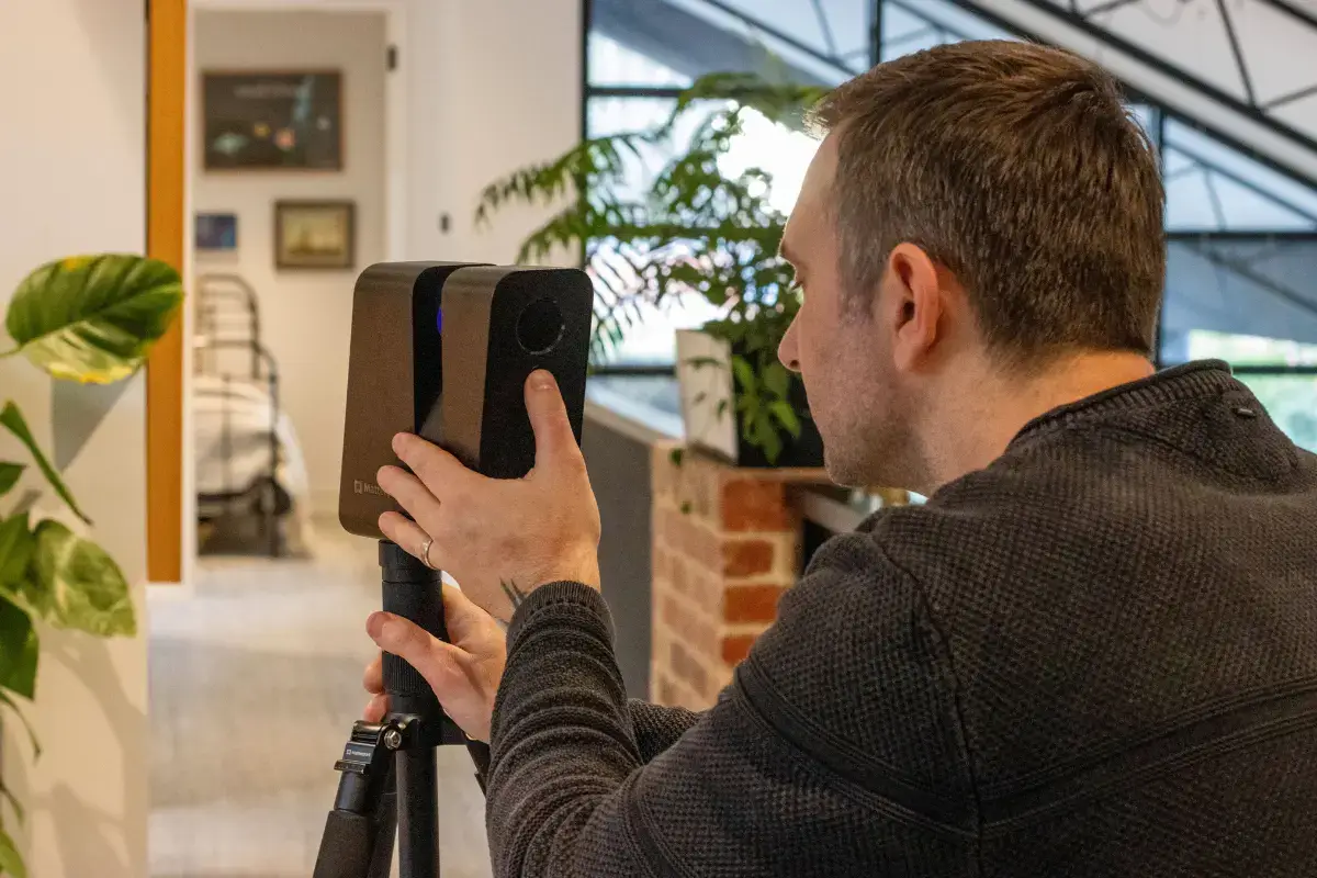 a man using a Matterport Pro3 LiDAR Camera with stand