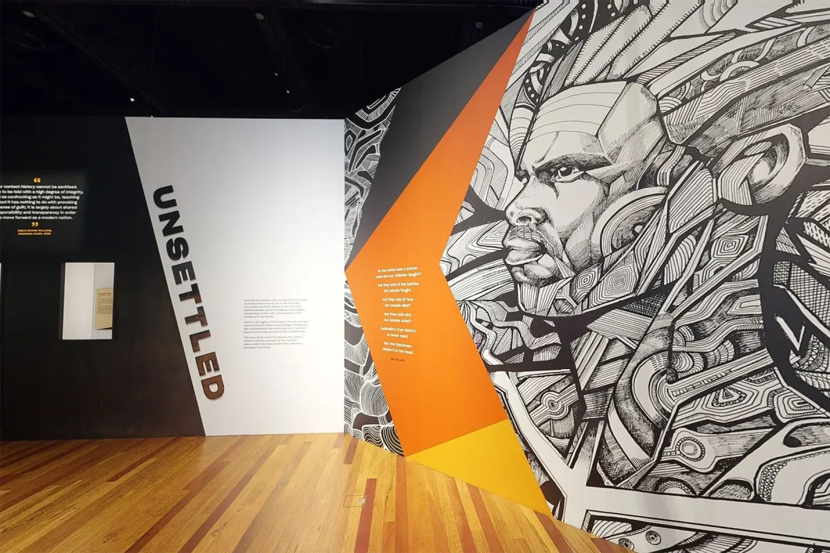 Exhibit space with an artistic mural depicting a stylized man's face